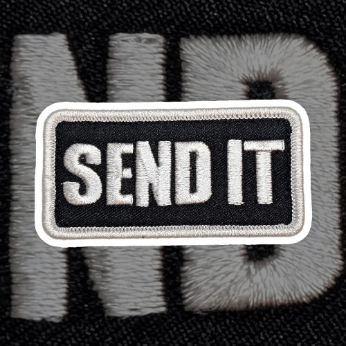 Embroidered patch with 'SEND IT' text on a textured background